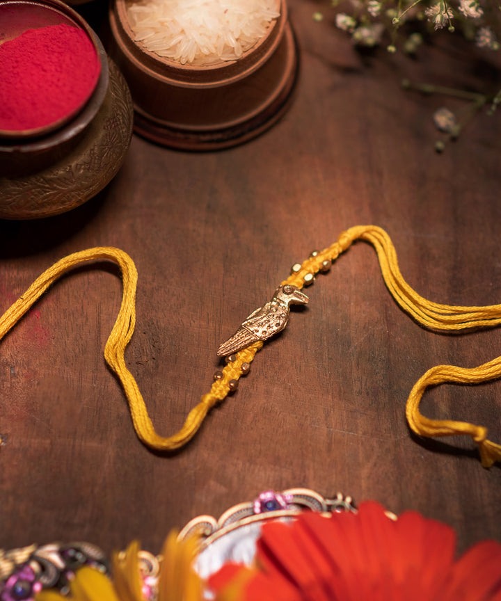 Handcrafted dokhra rakhi with yellow mercerised cotton thread