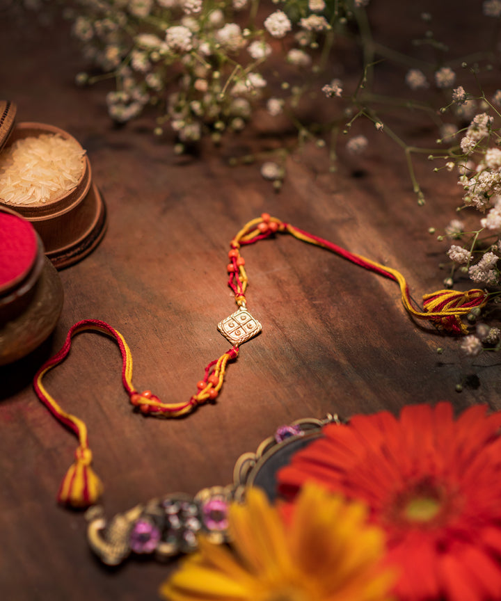 Handcrafted dhokra rakhi with multicolor mercerised cotton thread