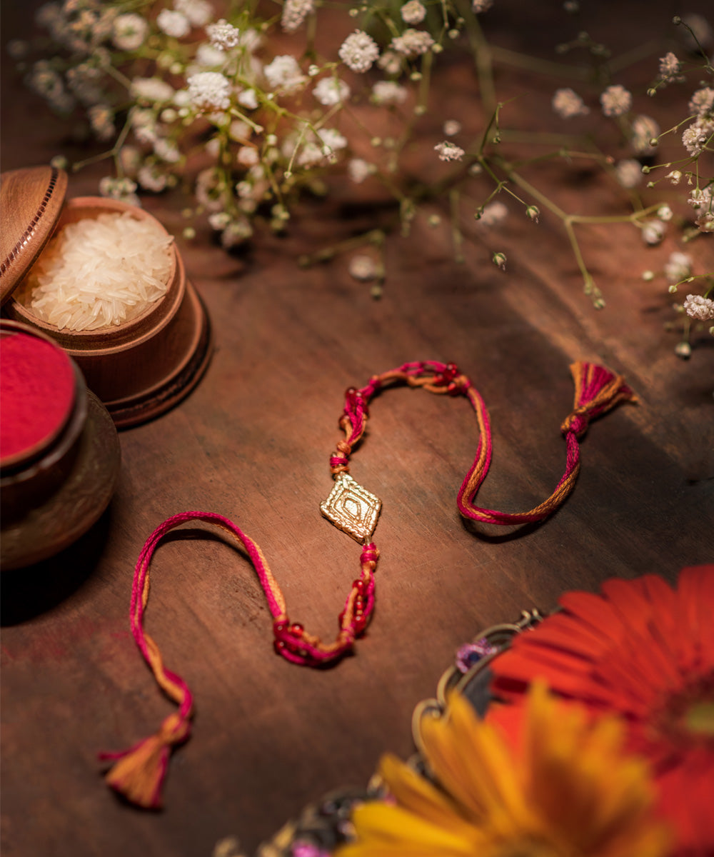 Handcrafted dhokra rakhi with pink mercerised cotton thread