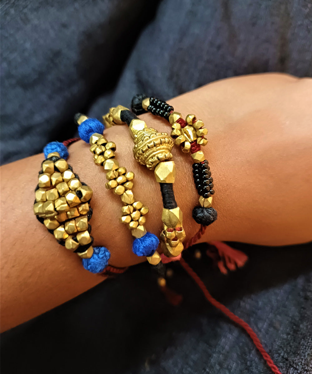 Hand crafted set of four dhokra brass rakhi with cotton thread