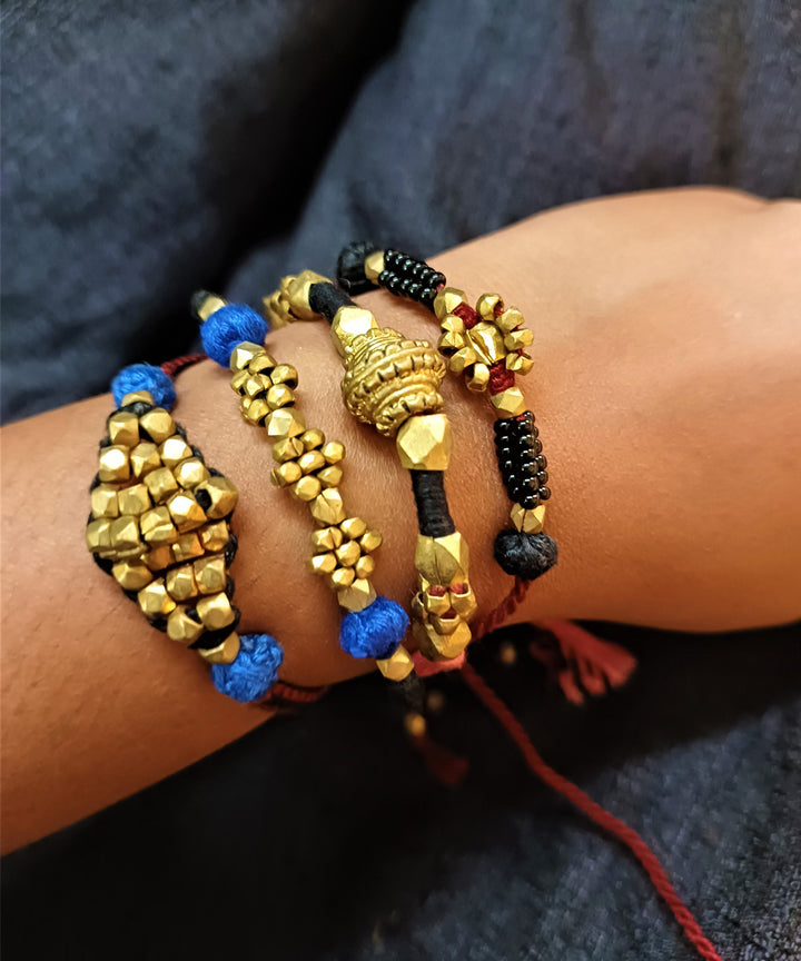 Hand crafted set of four dhokra brass rakhi with cotton thread