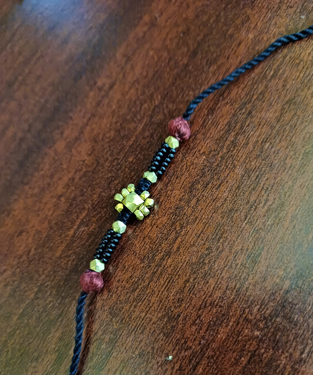 Hand crafted set of four dhokra brass rakhi with cotton thread