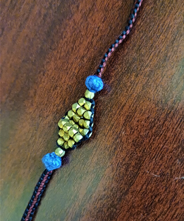 Hand crafted set of four dhokra brass rakhi with cotton thread