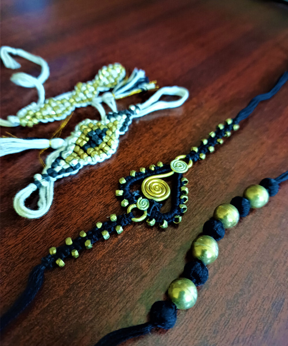 Handcrafted set of four dhokra brass rakhi with cotton thread
