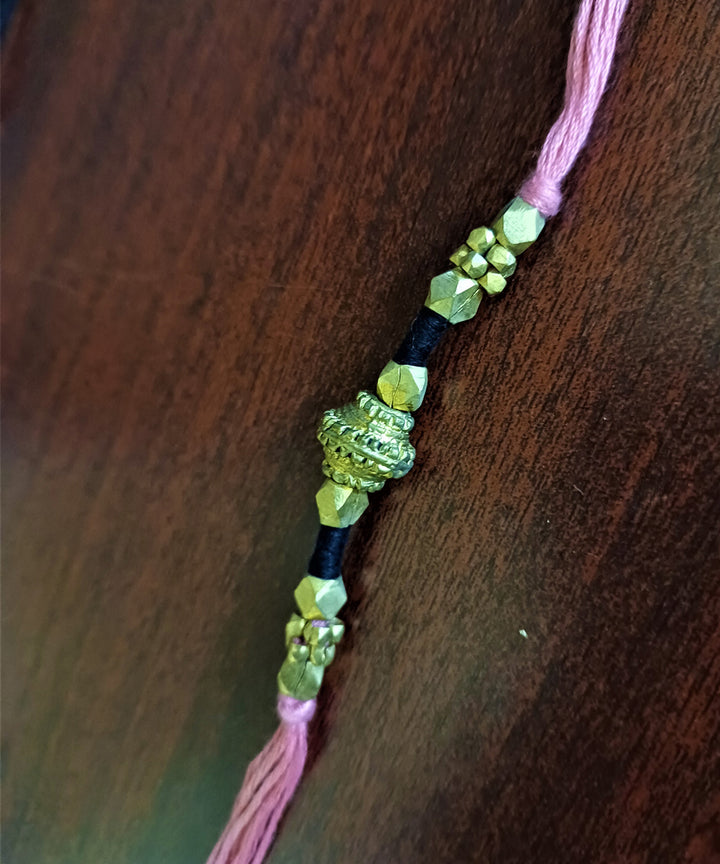 Hand crafted set of four dhokra brass rakhi with cotton thread