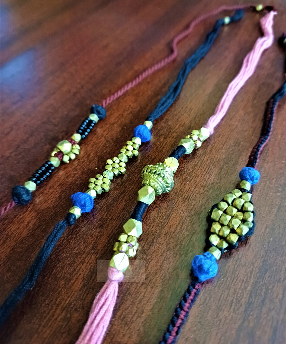 Hand crafted set of four dhokra brass rakhi with cotton thread