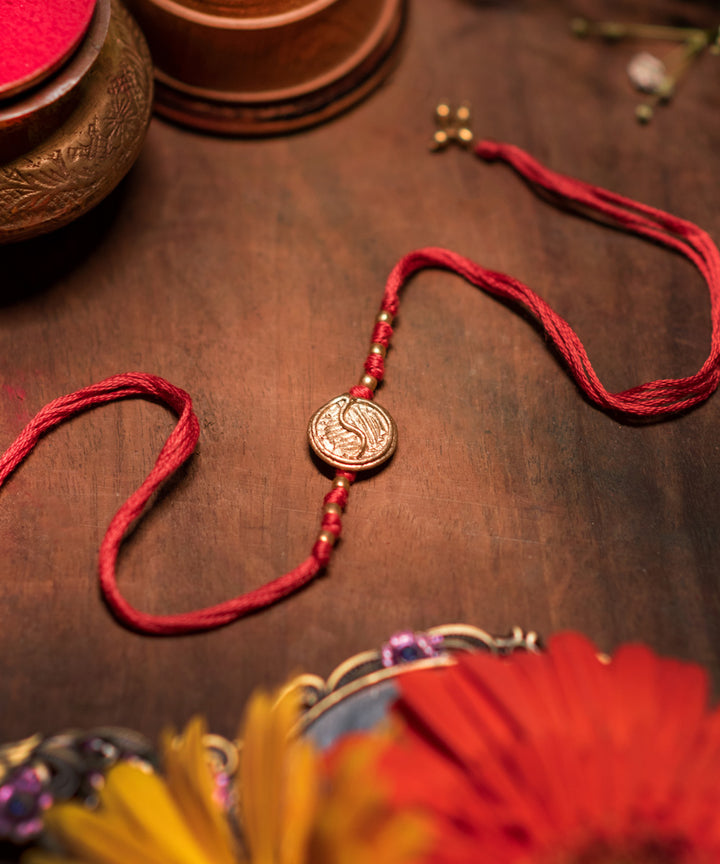 Hand crafted dokhra rakhi with red mercerised cotton thread