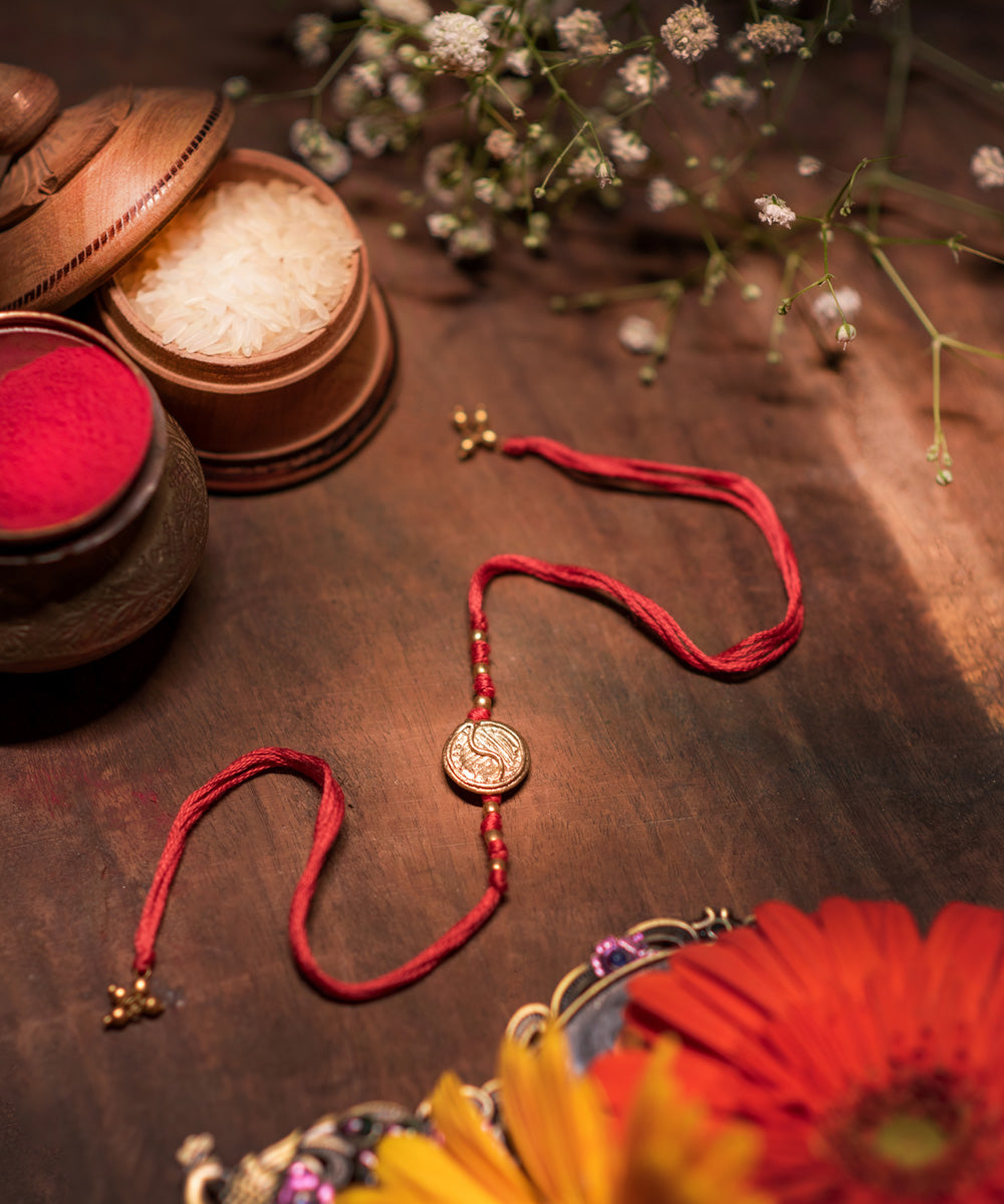 Hand crafted dokhra rakhi with red mercerised cotton thread