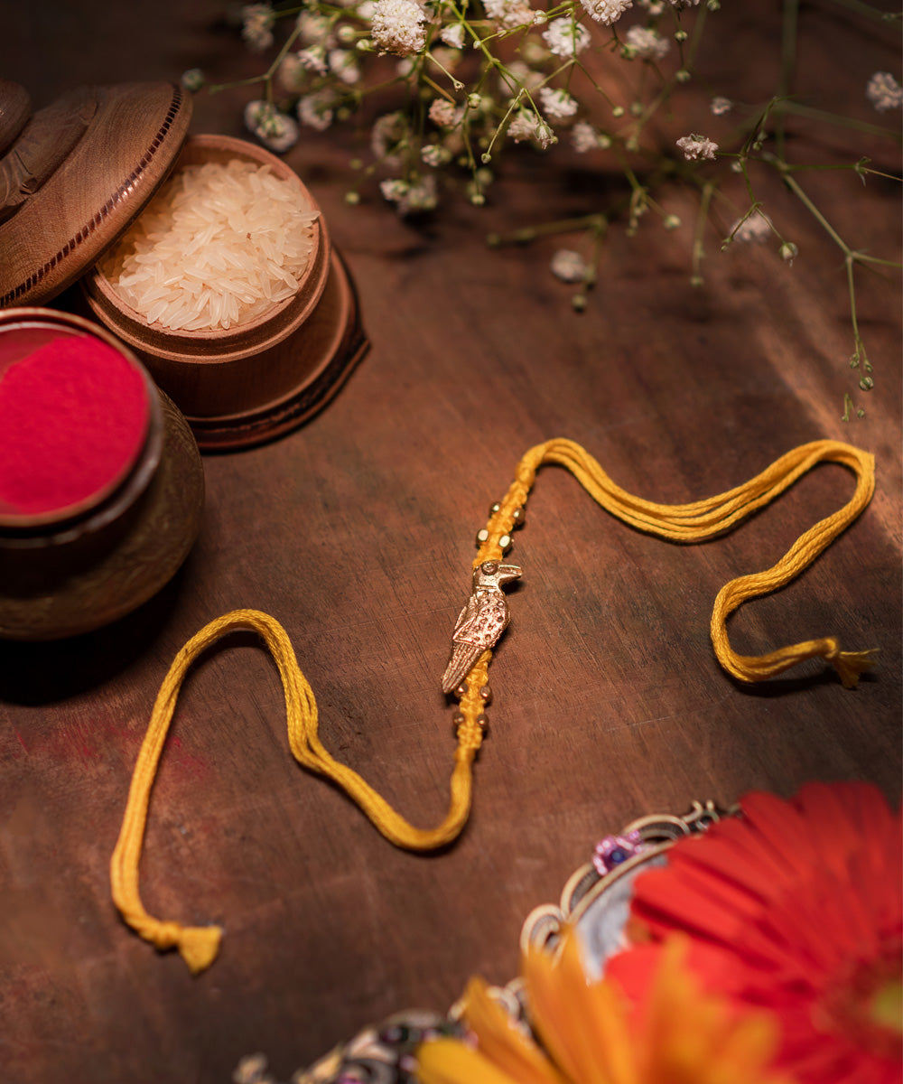 Handcrafted dokhra rakhi with yellow mercerised cotton thread