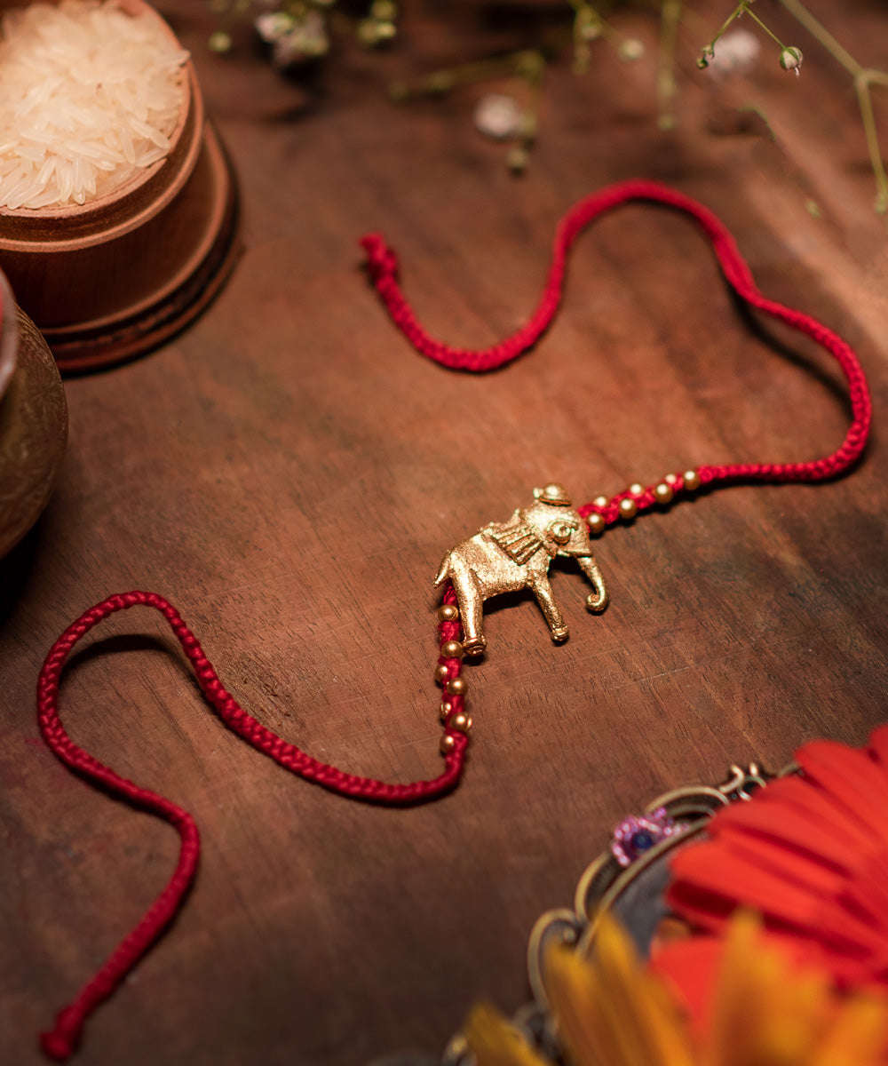 Hand crafted dhokra rakhi with red mercerised cotton thread