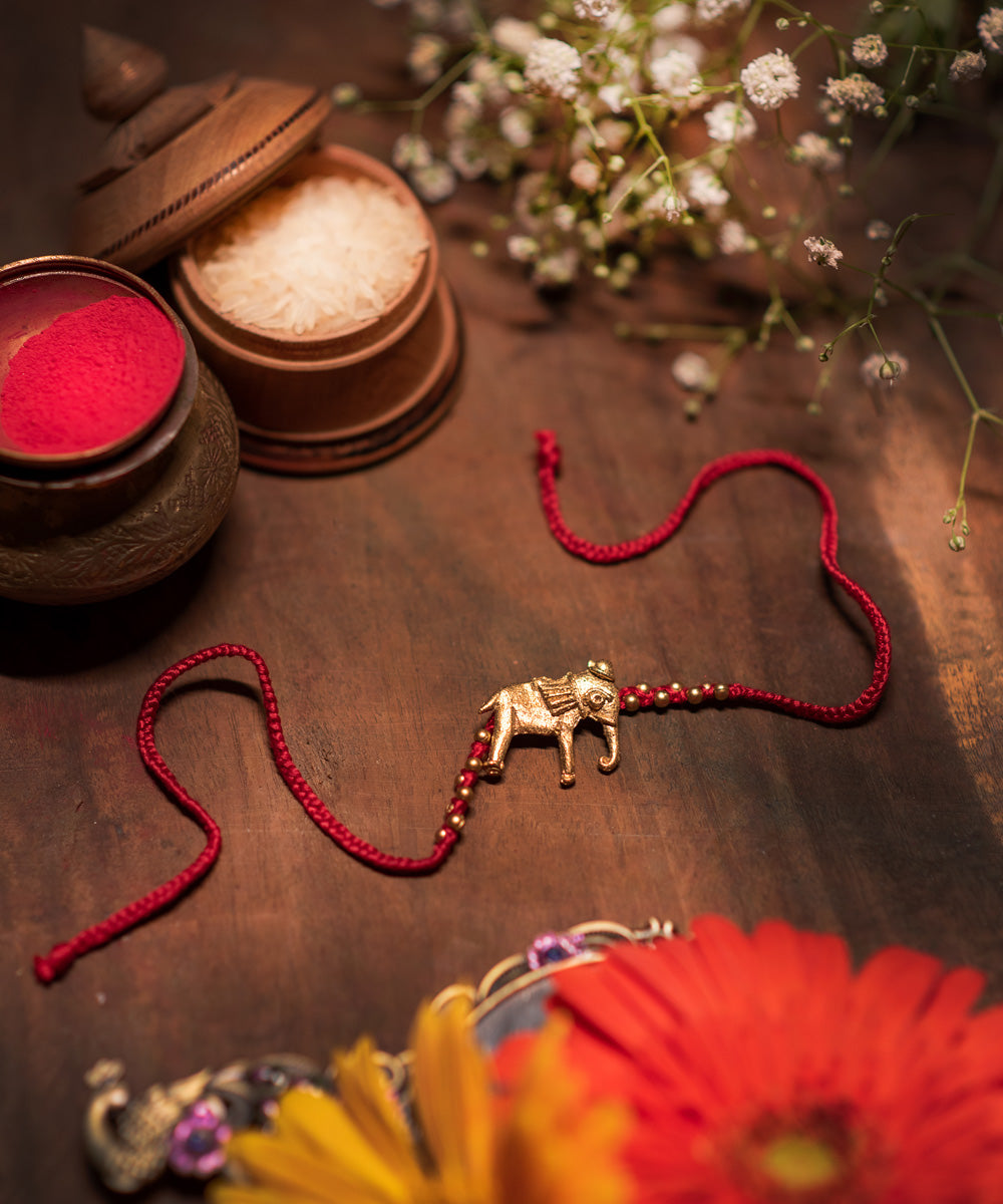 Hand crafted dhokra rakhi with red mercerised cotton thread