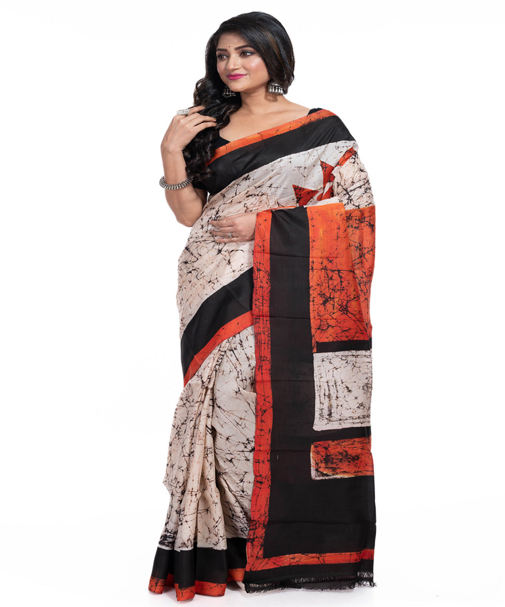 Cream black orange silk handwoven batik print saree