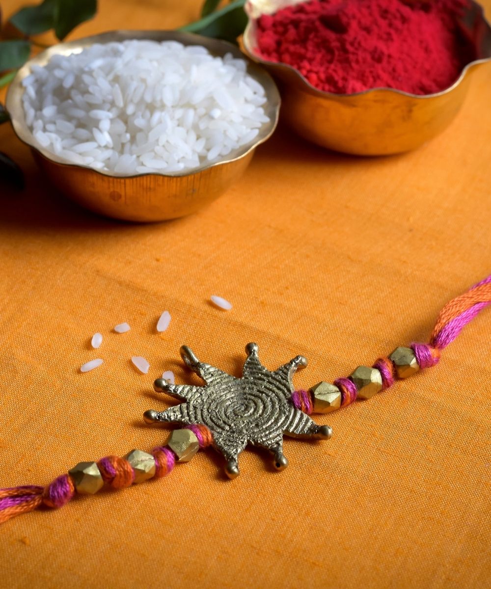Hand crafted dhokra rakhi with red mercerised cotton thread