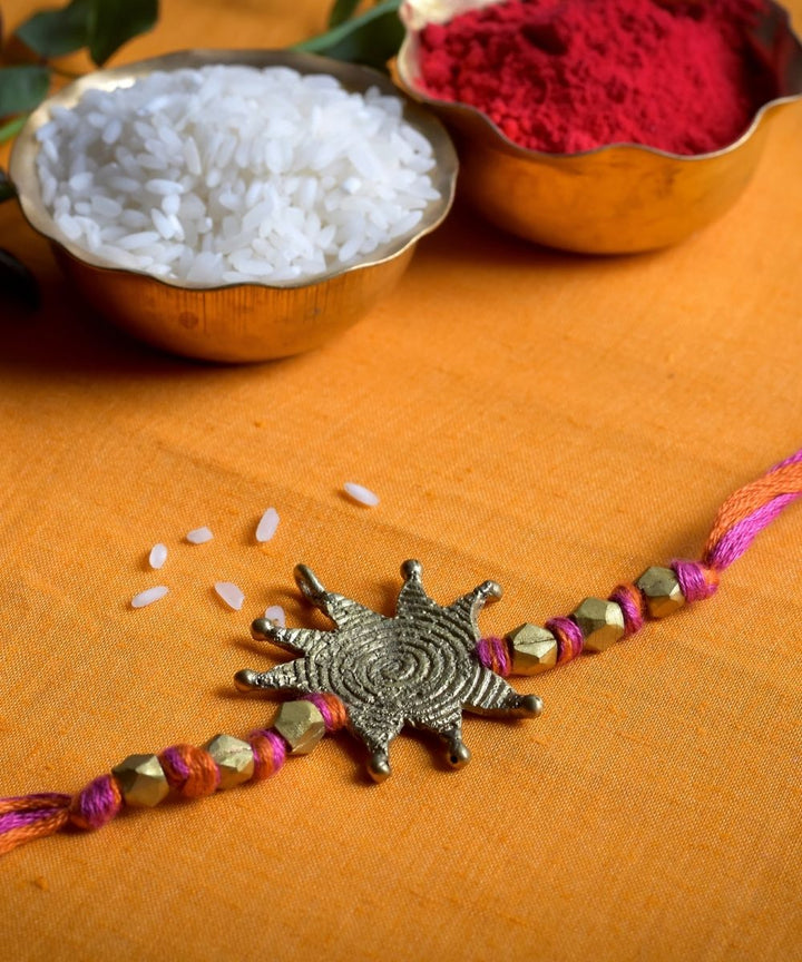 Hand crafted dhokra rakhi with red mercerised cotton thread