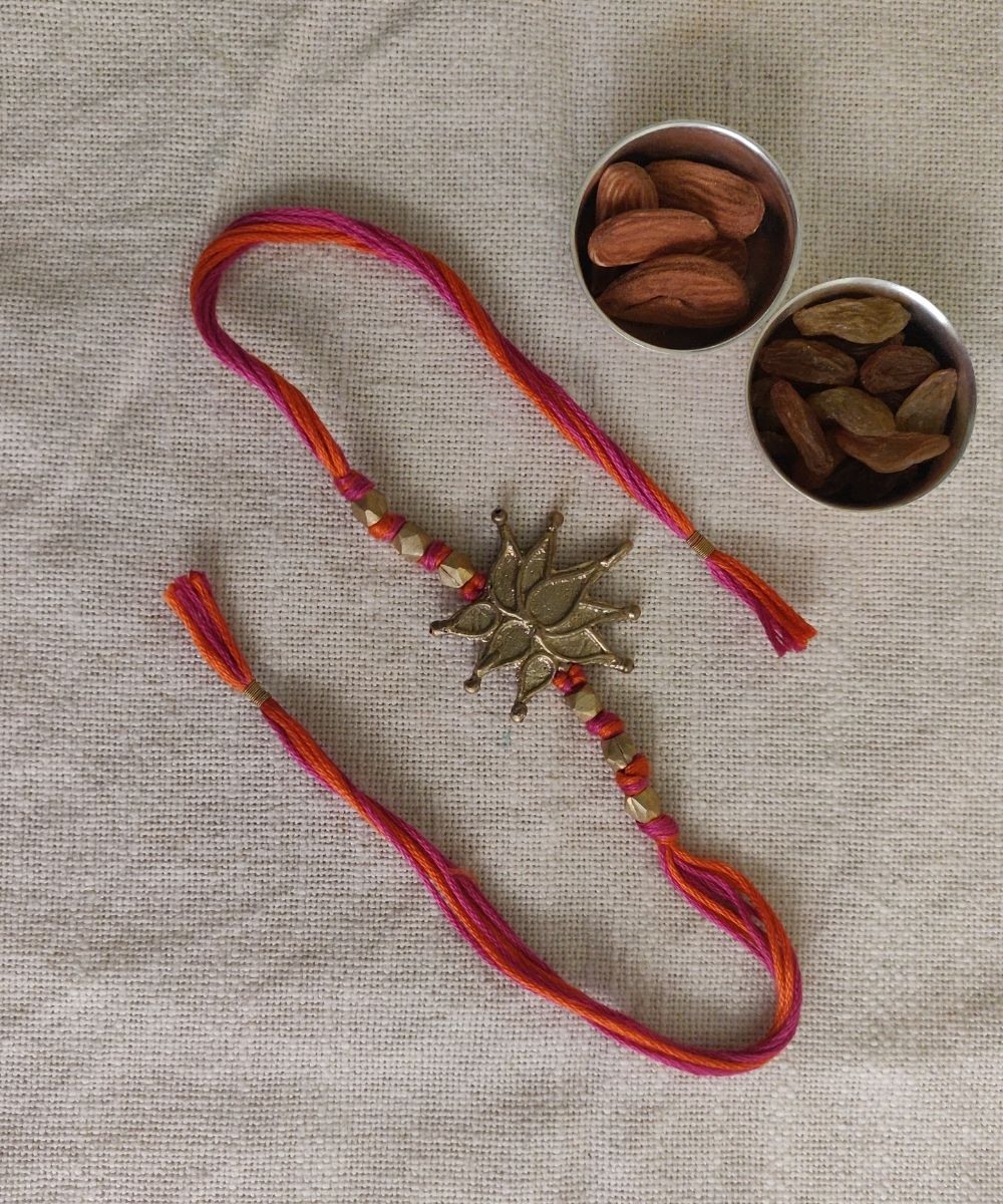 Hand crafted dhokra rakhi with red mercerised cotton thread