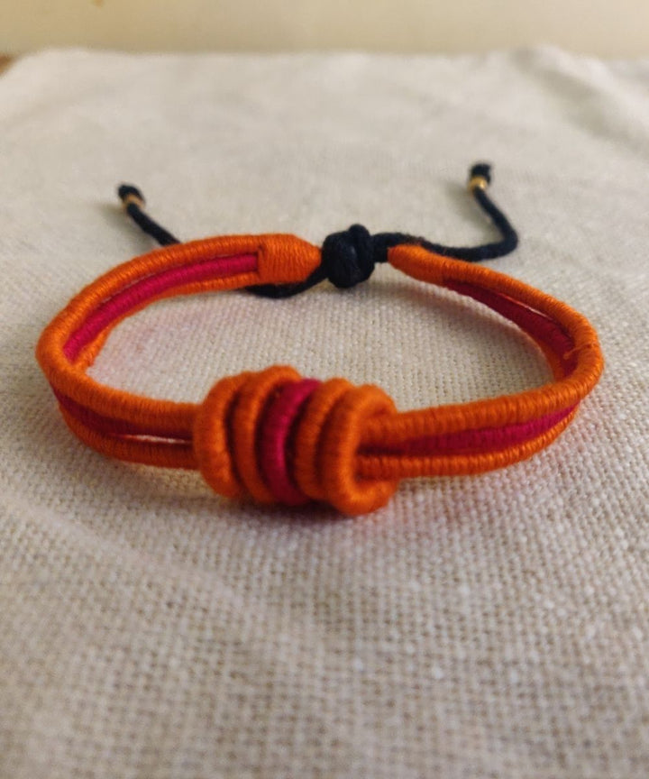 Handcrafted orange red rakhi with mercerised cotton thread
