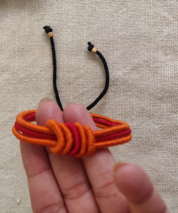 Handcrafted orange red rakhi with mercerised cotton thread